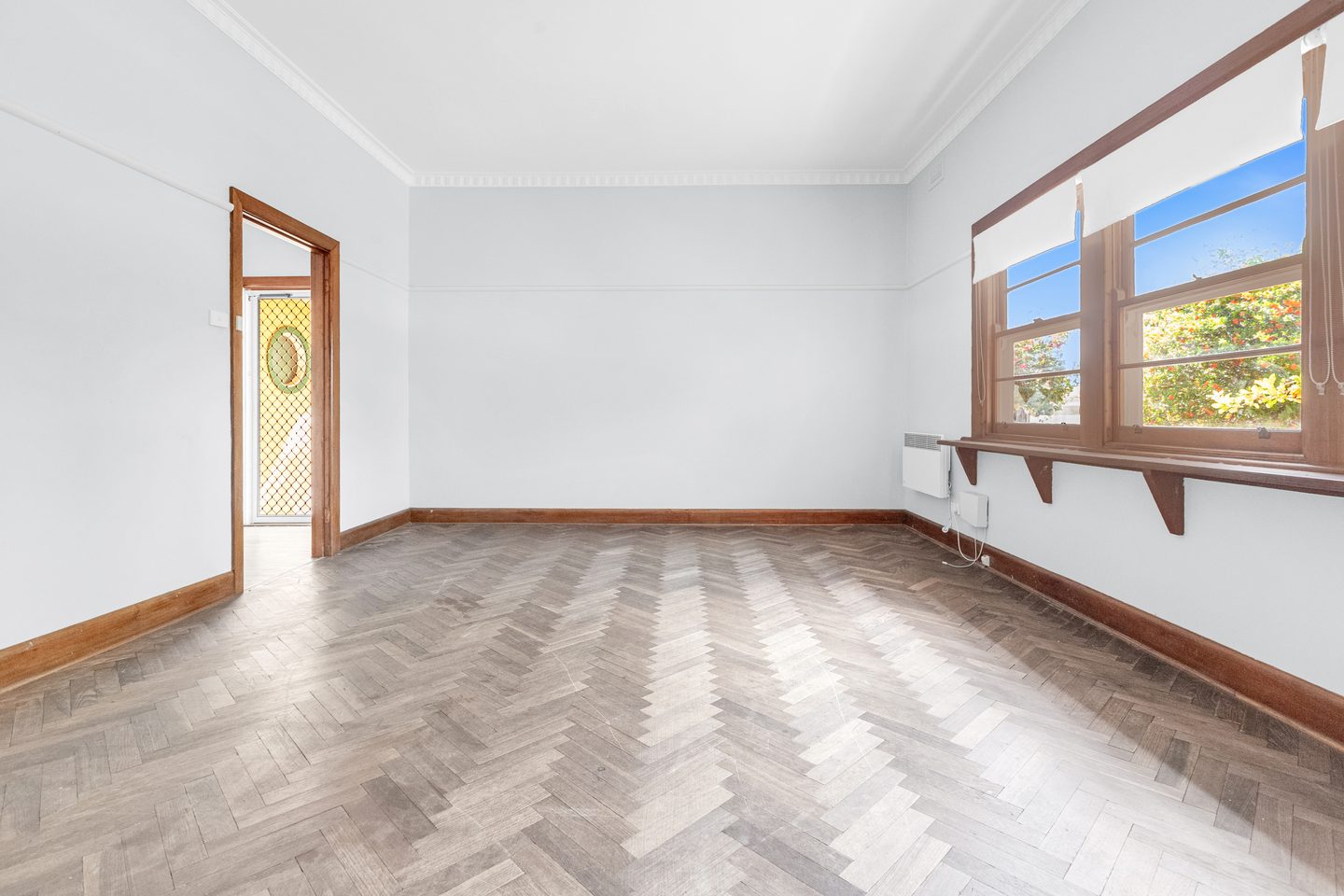 Living room with parquet flooring and timber-framed windows
