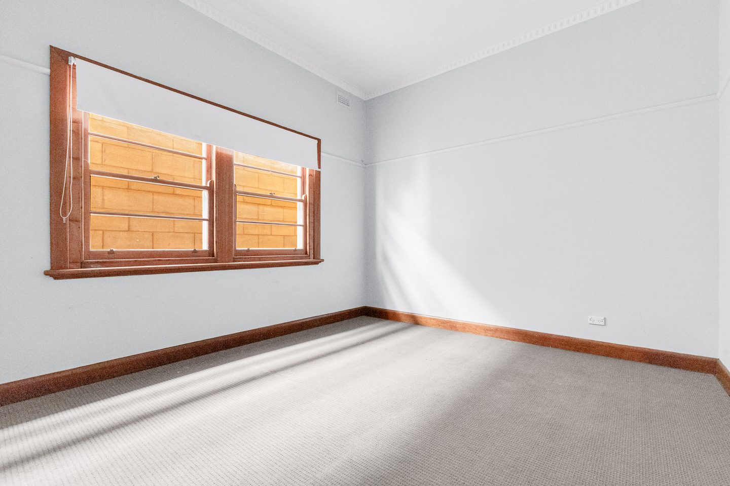 Carpeted bedroom with a timber-framed window