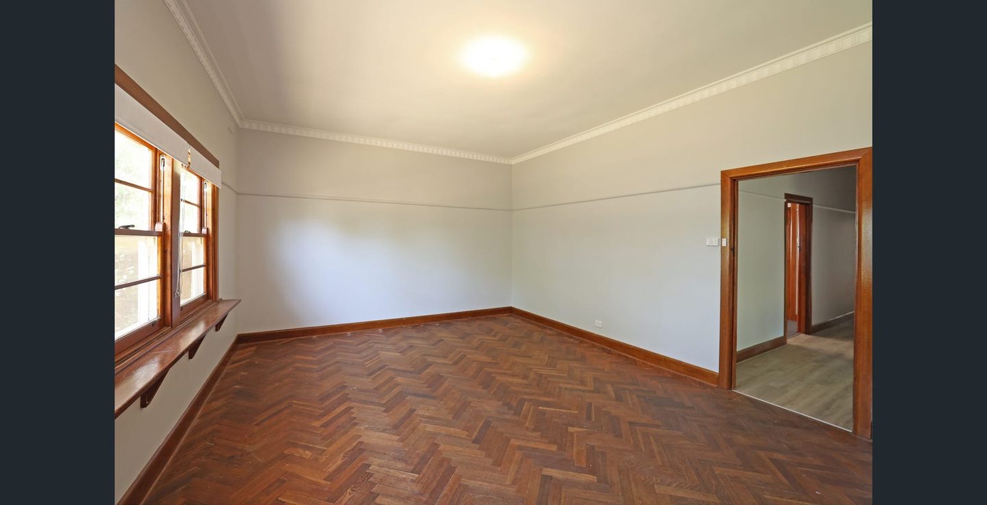 Living room with parquet flooring looking towards the hallway